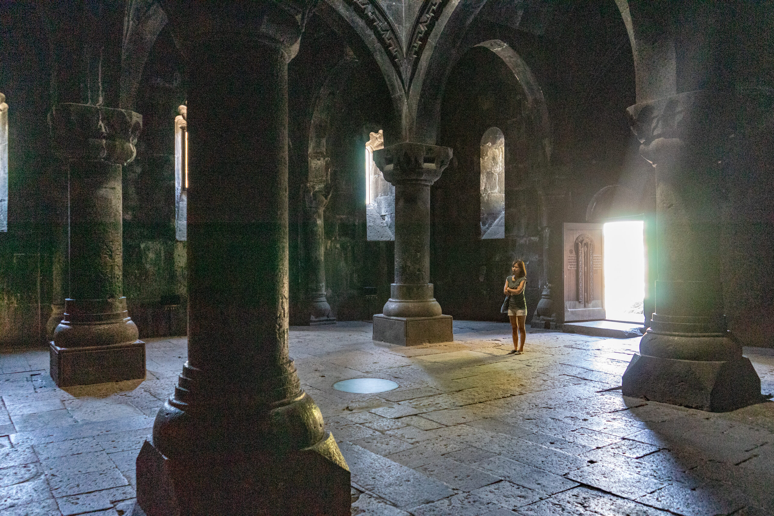Jin stand inside the stone interior of the Geghard Monastery in Armenia