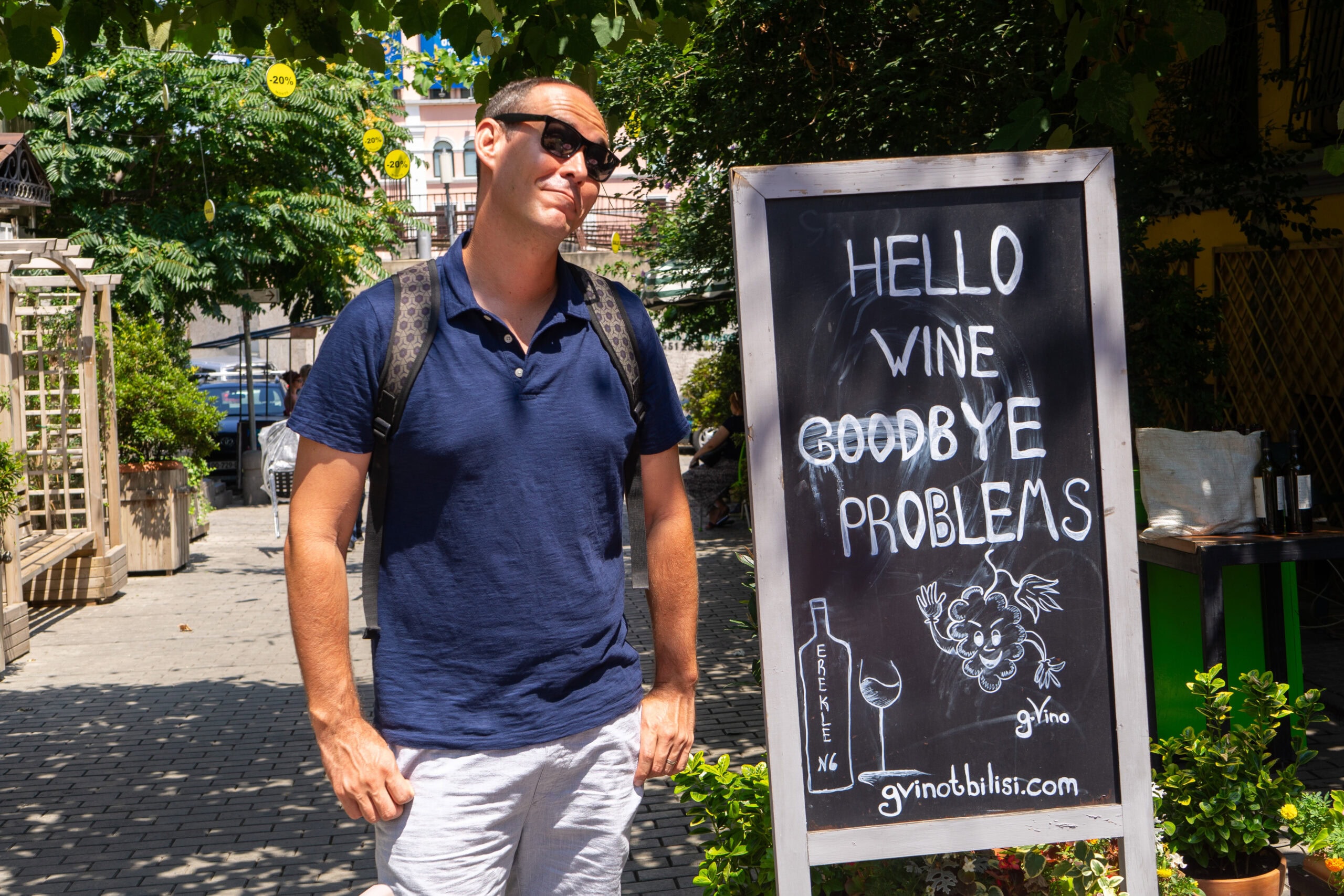 I am standing looking smug next to a sign in Tbilisi that reads: Hello Wine, Goodbye problems