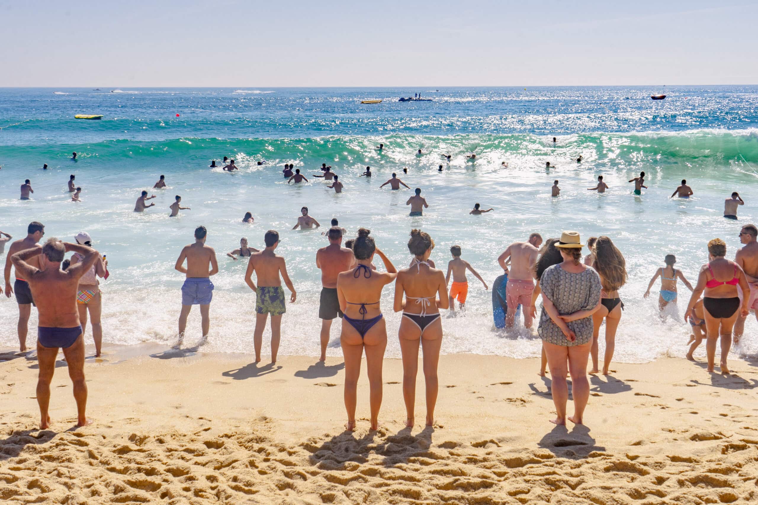 People on the beach in Nazare. Many are body surfing in the waves