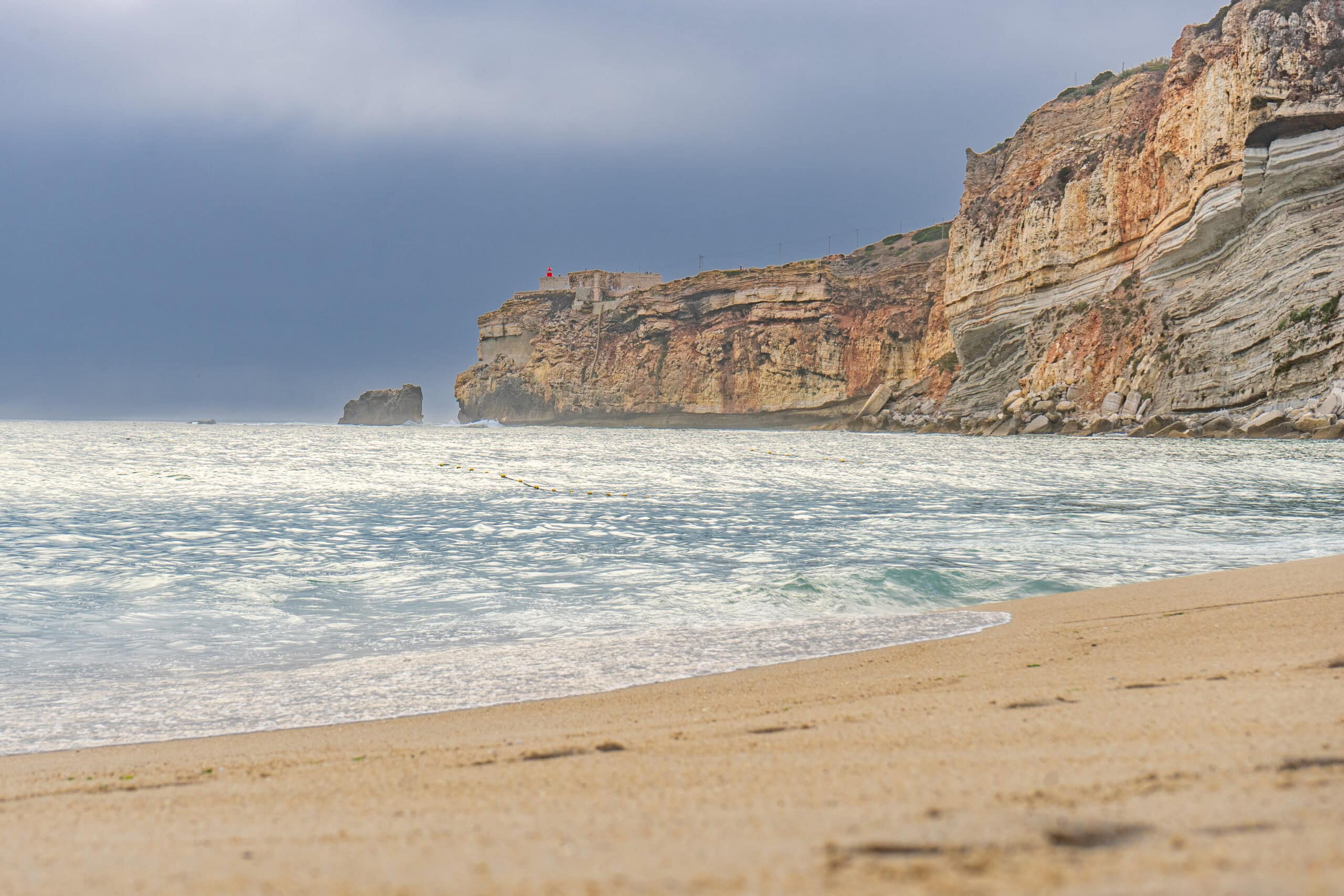Praia da Nazare in the late afternoon light. The cliff of Sitio and the Nazare light house can be seen in the background