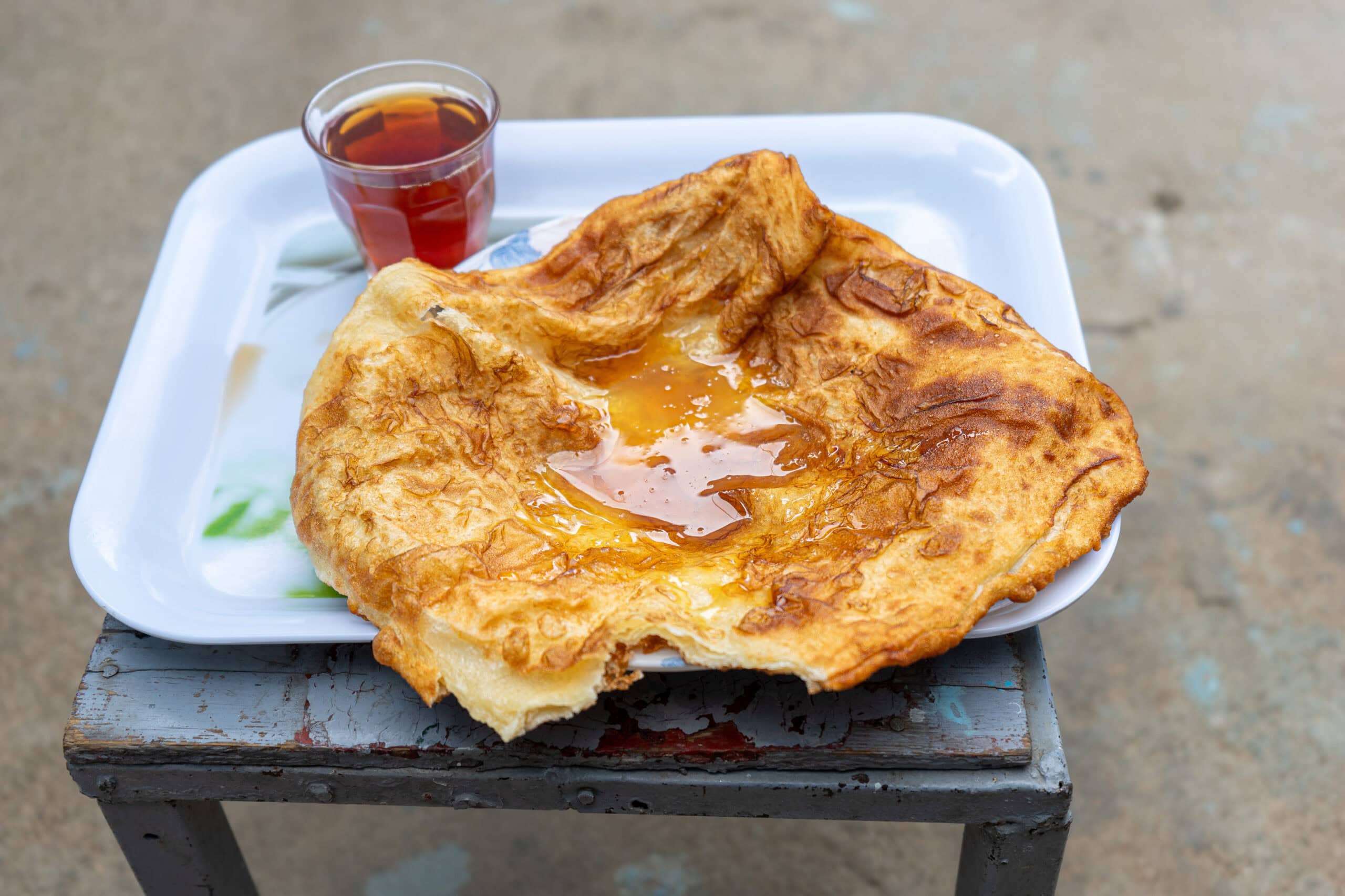fried flat bread with honey and a glass of tea for breakfast at Rowda Waber Guesthouse in Harar