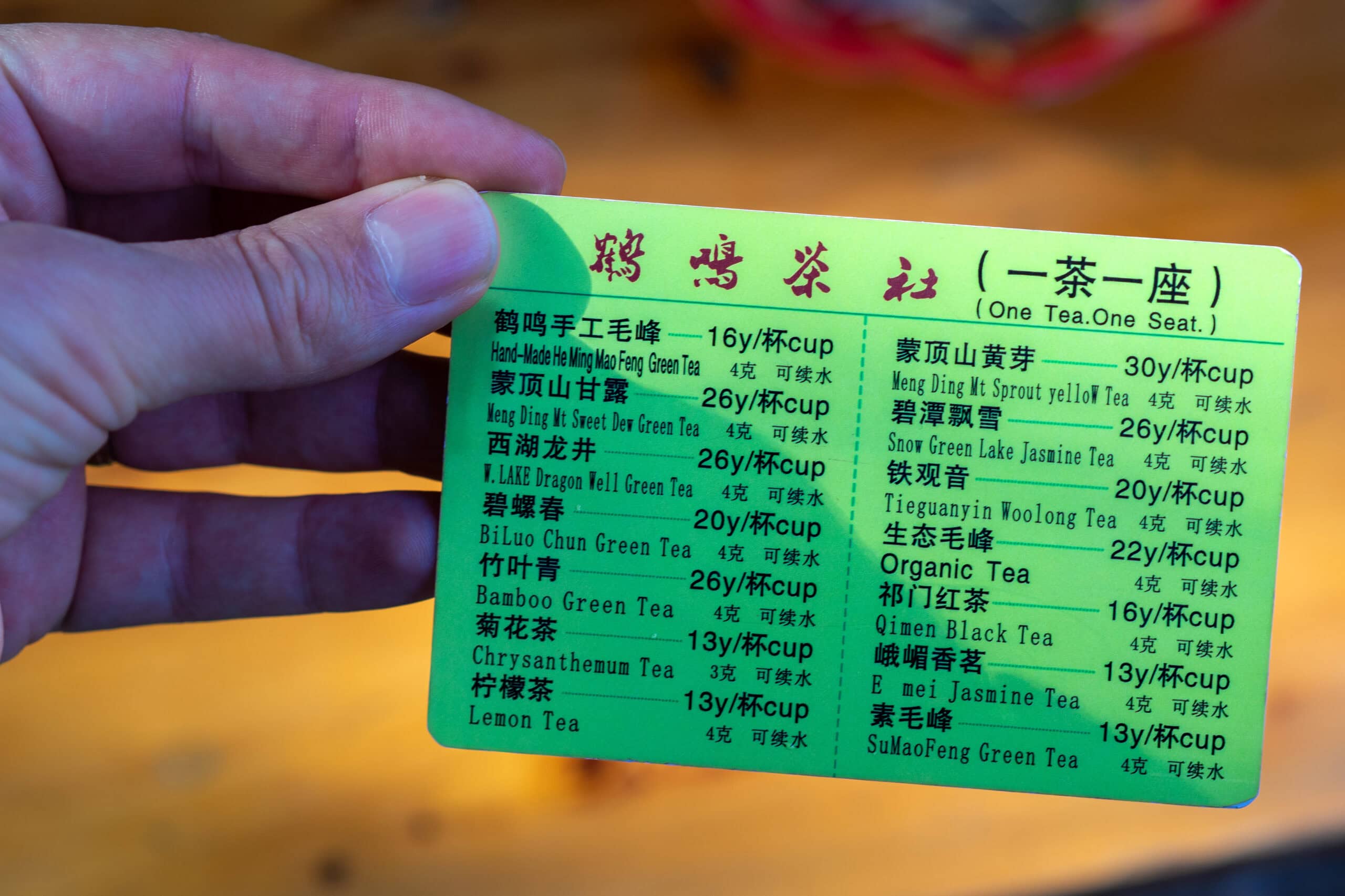 A small green card with a list of teas and prices : tea menu, Heming Teahouse, Chengdu