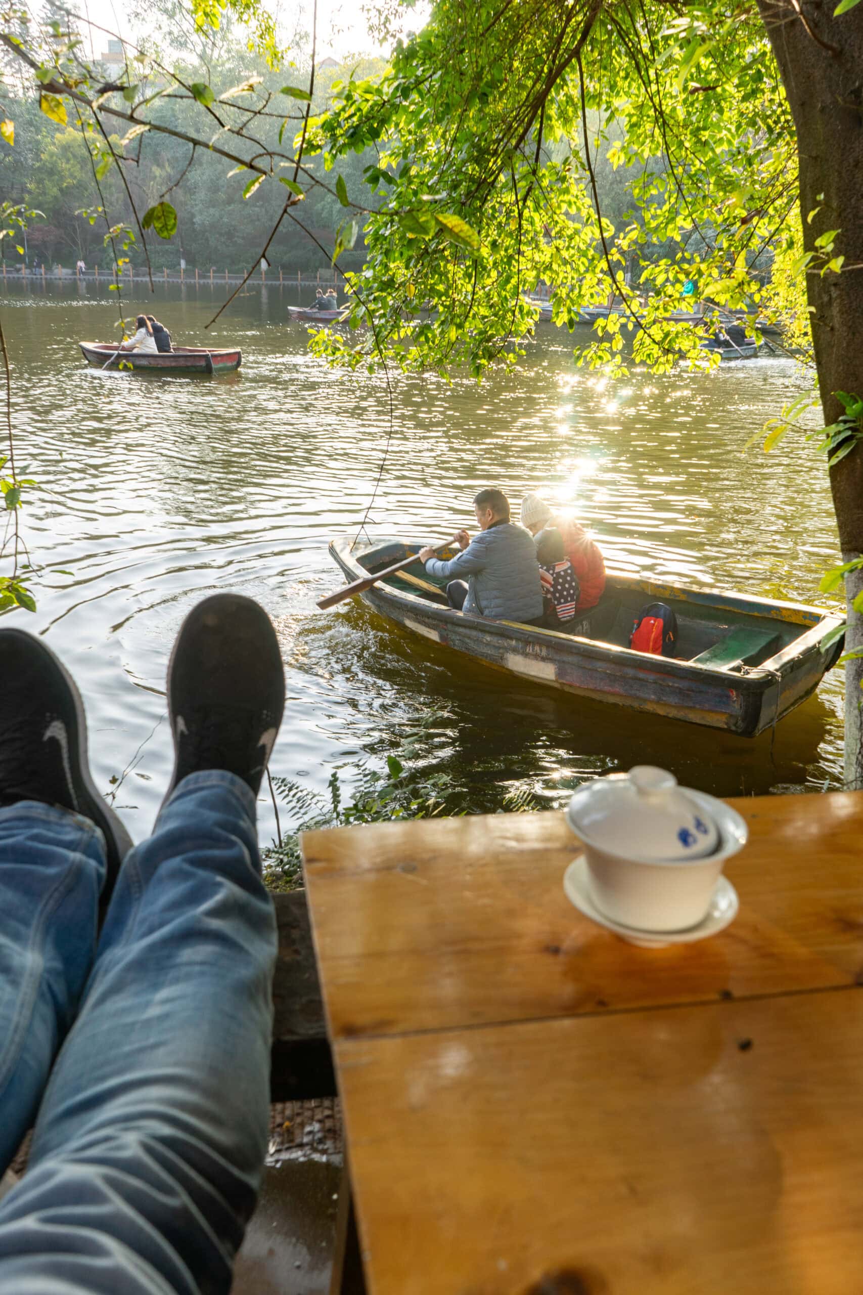 I sit with my legs stretched out with a view of couples rowing boats on the lake at Heming Tea House. You can see my cup of tea sitting on the table