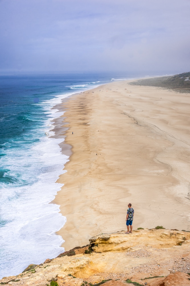 A man overlooks Praia do Norte beach in Nazare