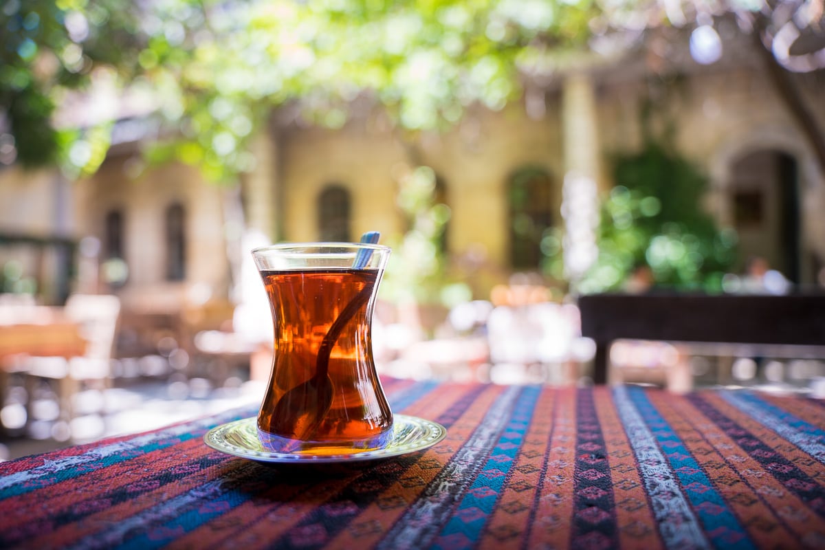 Traditional Turkish tea served in a tulip shaped glass in a leafy courtyard at a Papirus cafe in Gaziantep