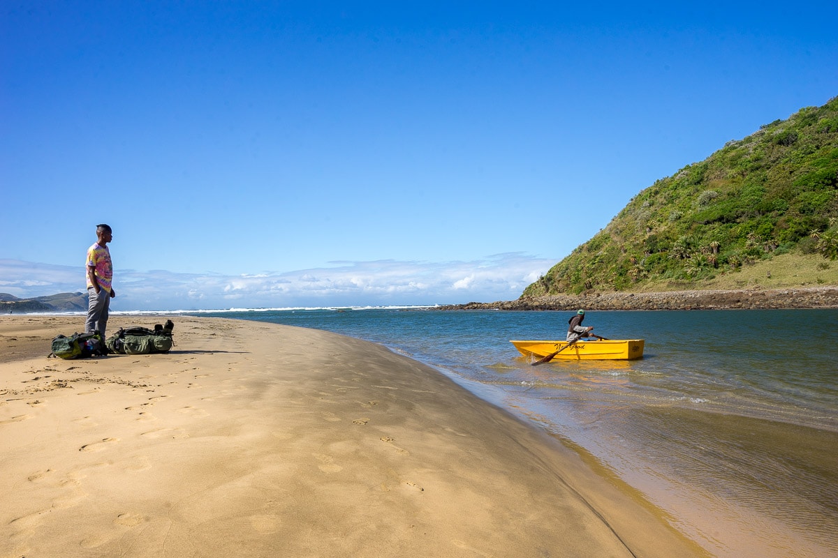Hiker waiting at the uMngazana River for a little yellow row boat to take him across the river