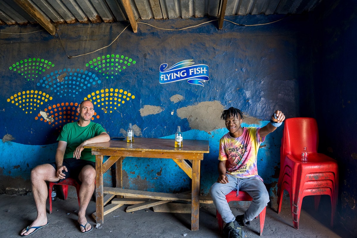 Traveller and local Xhosa guide having a beer in a shebeen while walking between Port St Johns and Coffee Bay