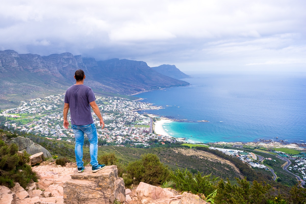 A man looks over Camps Bay and theTwelve Apostle mountains on the Lions Head Hike in Cape Town
