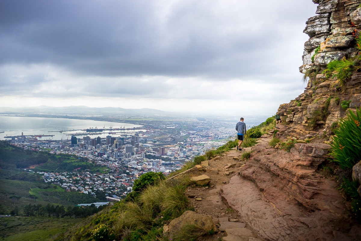 Hiking Lion's Head in Cape Town: A single hiker with the Cape Town city centre and harbour in the background