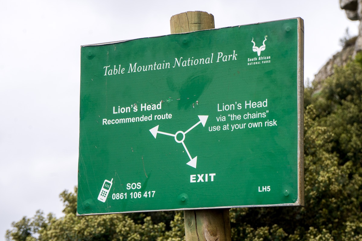 A sign on Lion's head showing different routes and a number to call in case of emergency 