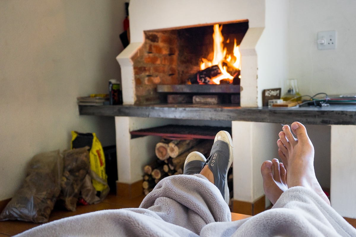 A couple enjoying a fireplace at Trogon Cottage in Magoebaskloof - affordable weekend getaways Limpopo