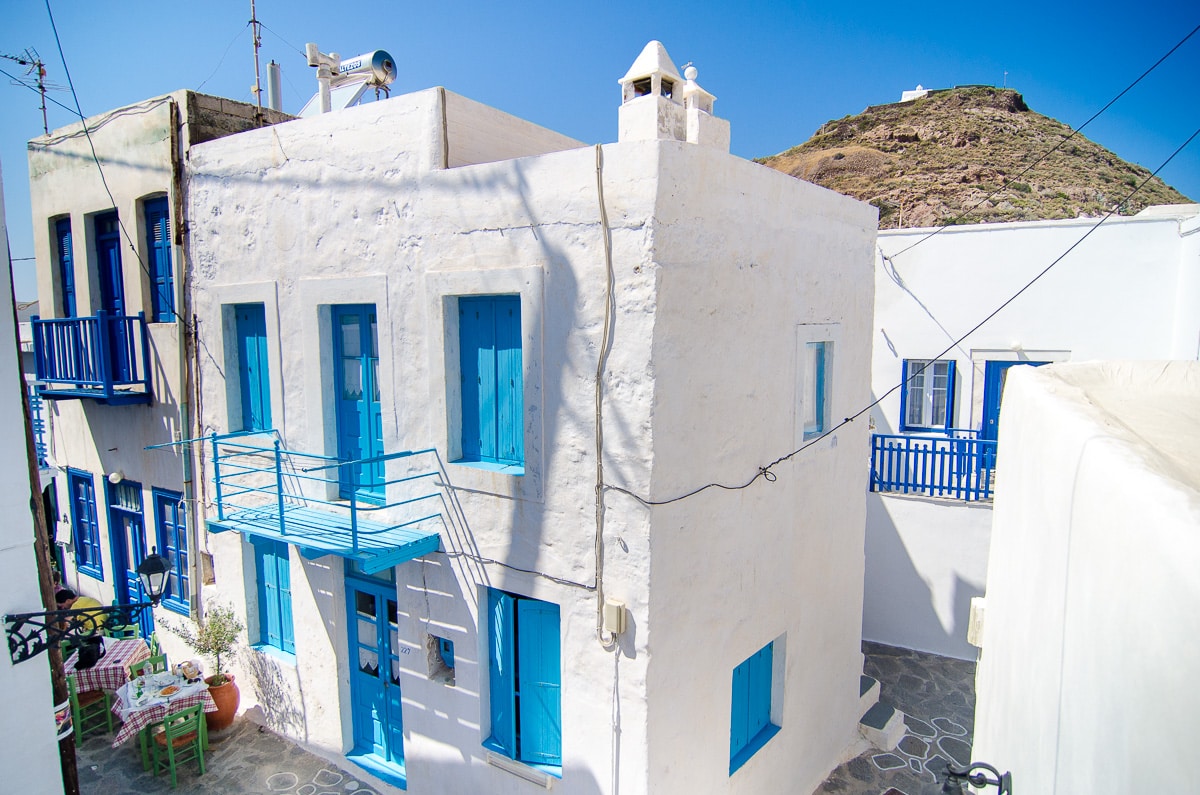White washed building with blue doors and shutters in Plaka Milos