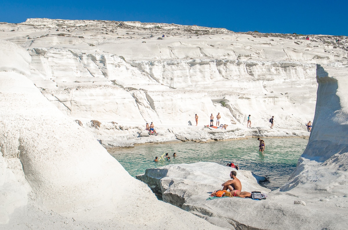 People swimming and sun bathing at Sarakiniko Beach on Milos island