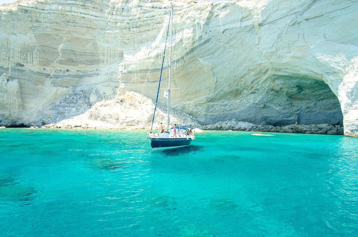 A yacht in front of a white cliff and cave at Kleftiko