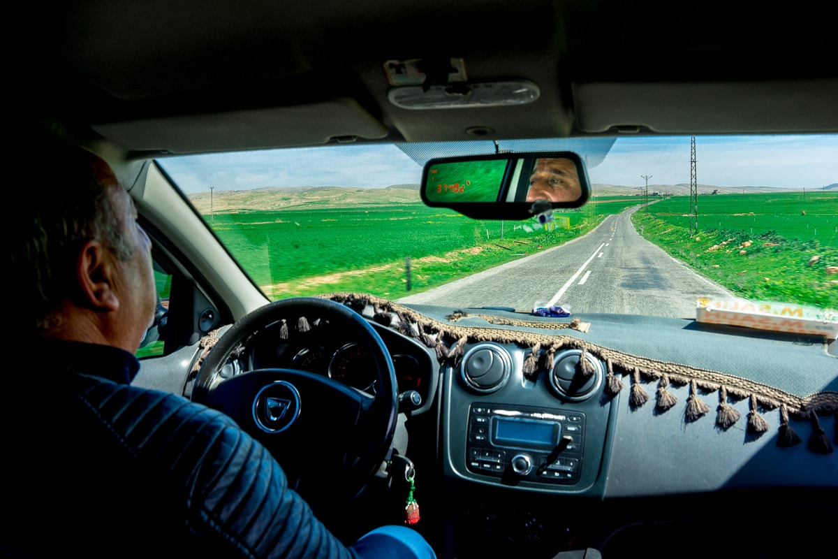 A taxi drives through the Mesopotamian plain between Mardin and Dara