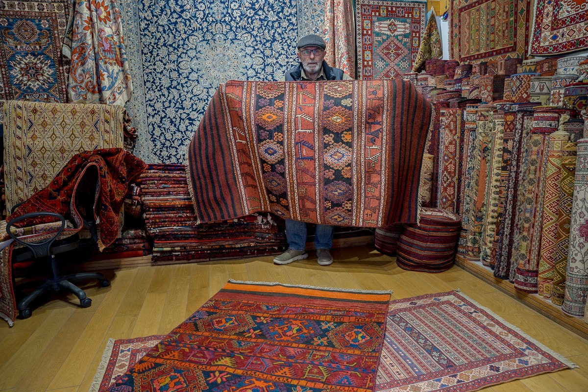 A carpet dealer showing off a Turkish rug in the Arasta Bazaar, Istanbul