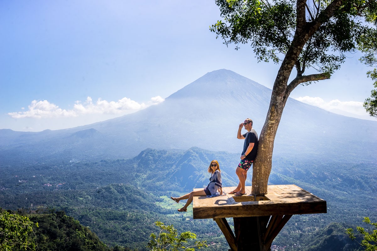 we are standing on a platform in a tree posing at Lahangan Sweet with Mount Agung in the background