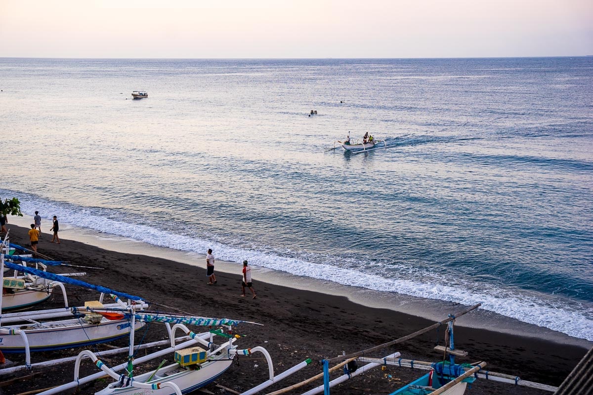 A traditional jukung fishing boat comes ashore on Amed Beach, Bali