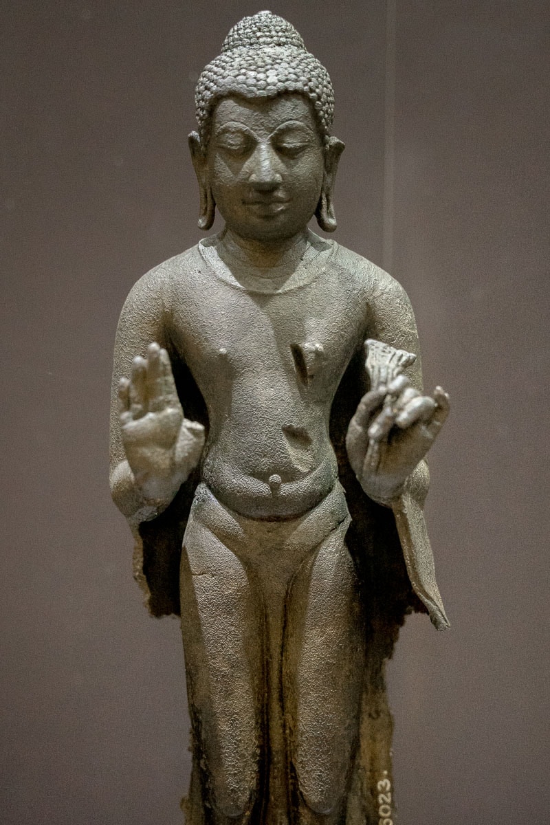 A standing figure of Buddha in bronze