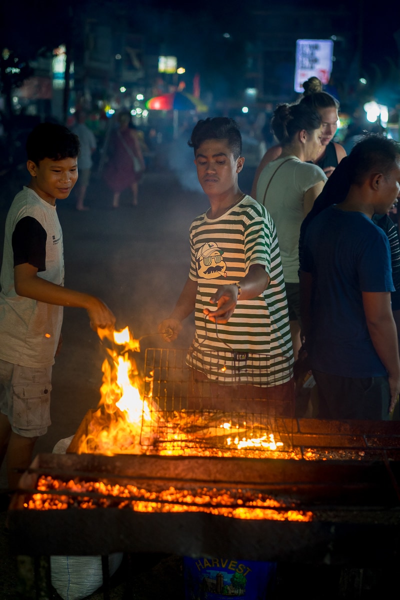An Indonesian man getting his fire and grill ready at the Labuan Bajo night market, Flores, Indonesia