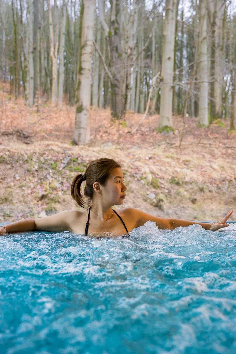 A photo of Jin relaxing in the whirlpool at Svoboda Spa Hotel in Marienbad. You can see the woods right behind her through he large windows