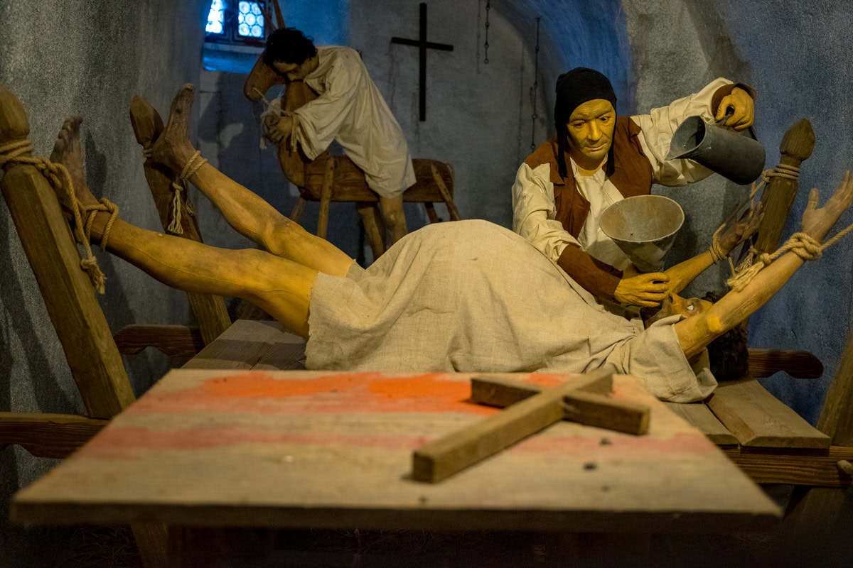 A diaroma of torture methods in the Loket Castle. Here you can see someone forcing the victim to drink water while a person sits on the wooden horse behind them