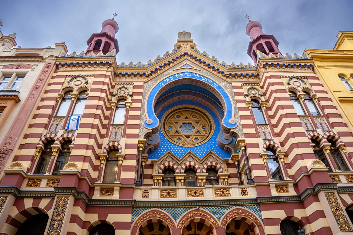 The facade of the Jerusalem Synagogue in Prague. You can see a blue horseshoe-shaped arch with a yellow Star of David as a window inside it.