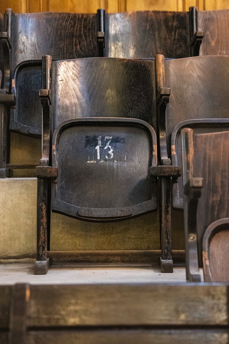 A photo of the fold up wooden chairs under the organ of the Jerusalem Synagogue. This one has the numbers 13 and 17 on it