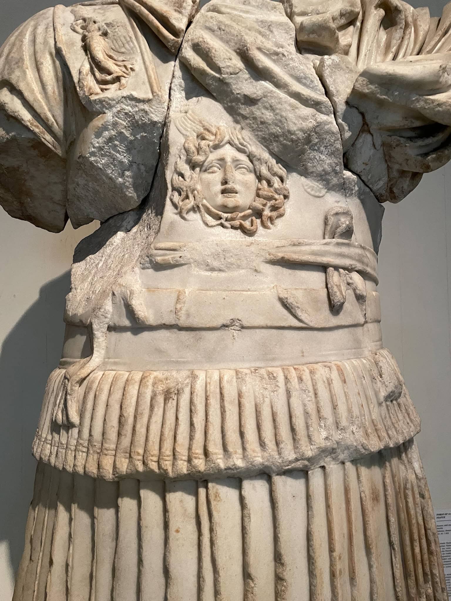 Detail of the armour of the Torso of a Cuirassed Statue. There is an emblem of Medusa on the statue's armour on his chest