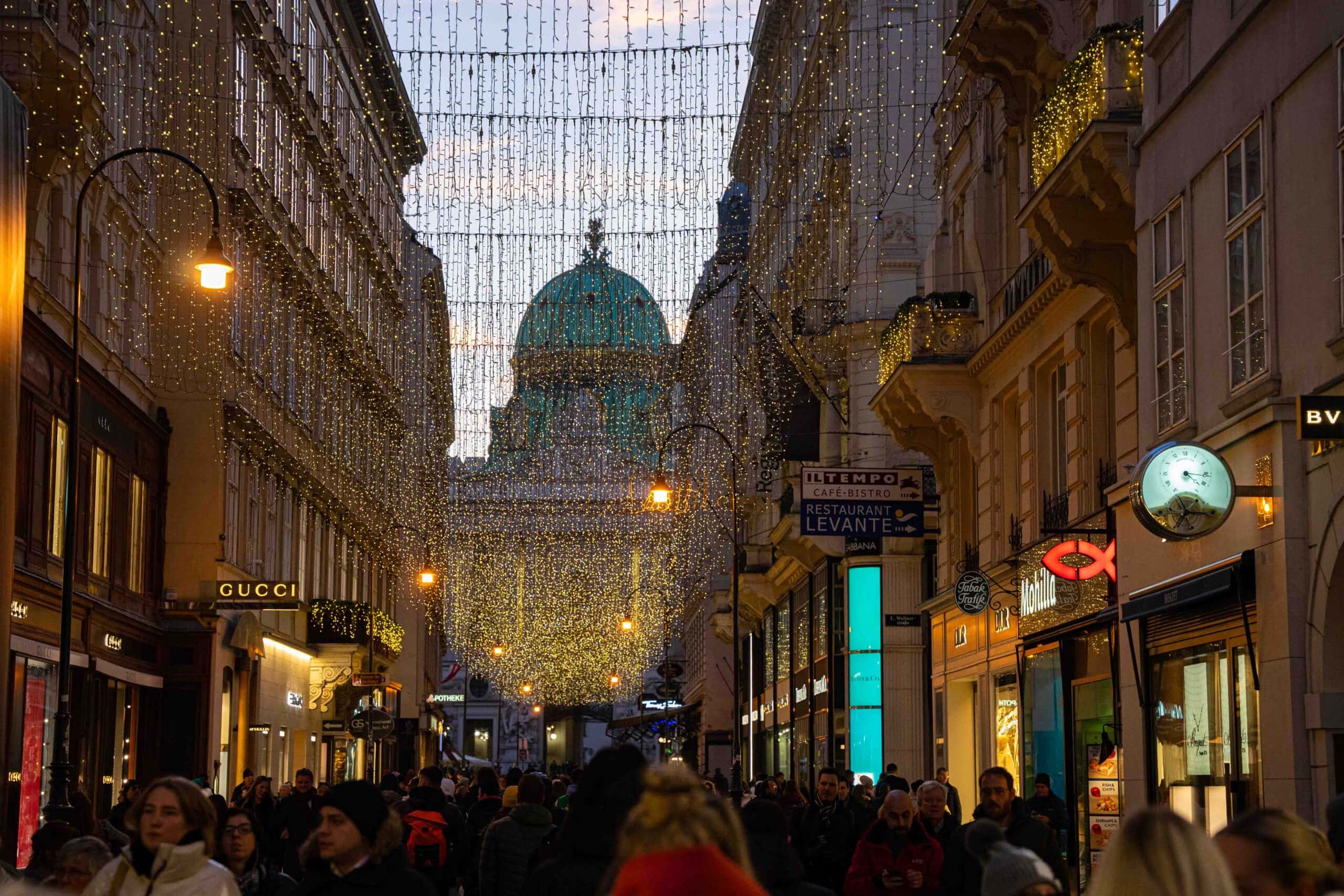 Vienna in December, Kohlmarkt lit up with Christmas lights with the dome of the Hofburg Palace in the background