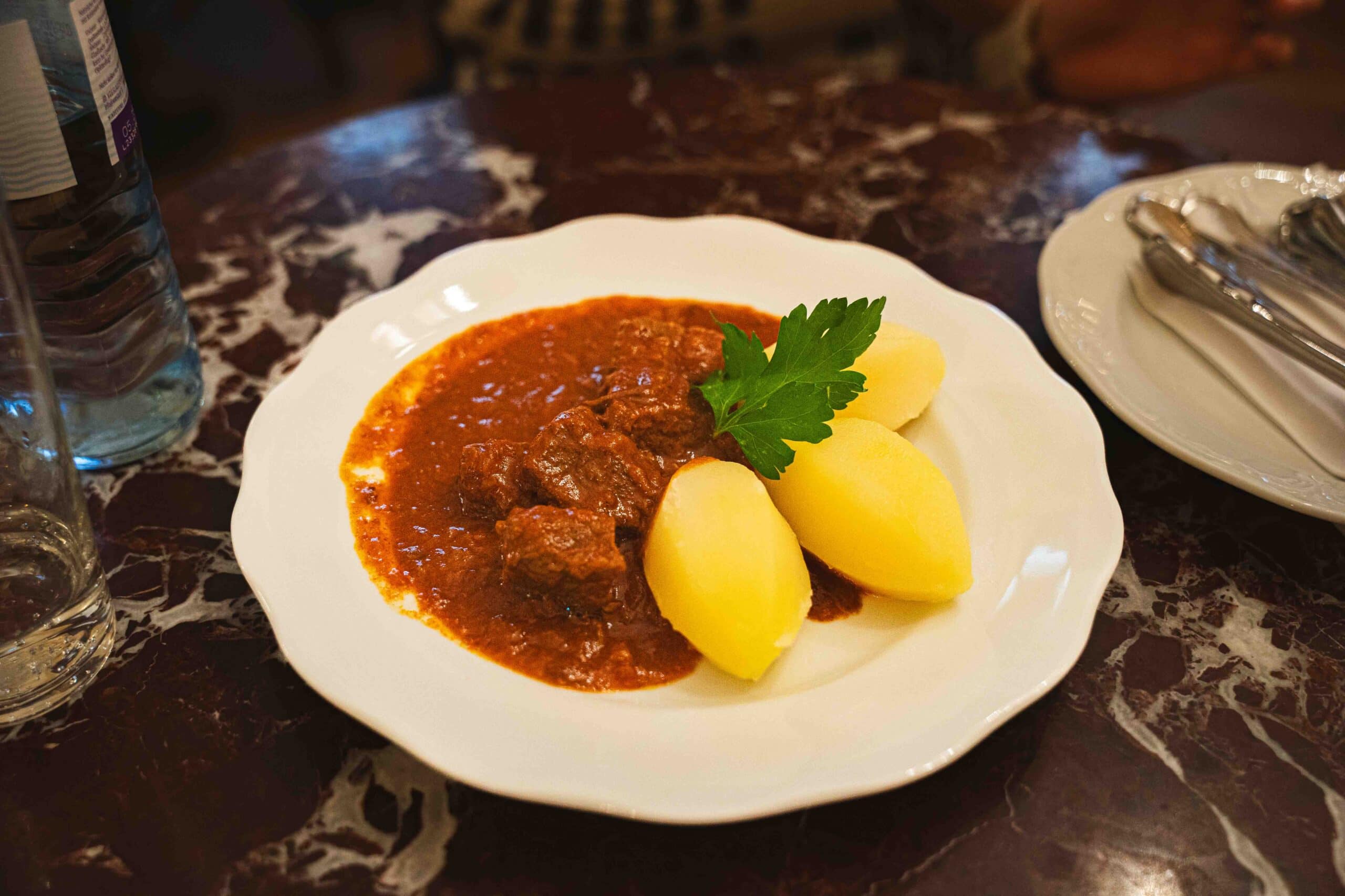 A plate of goulash with three potatoes that we shared at Cafe Demel