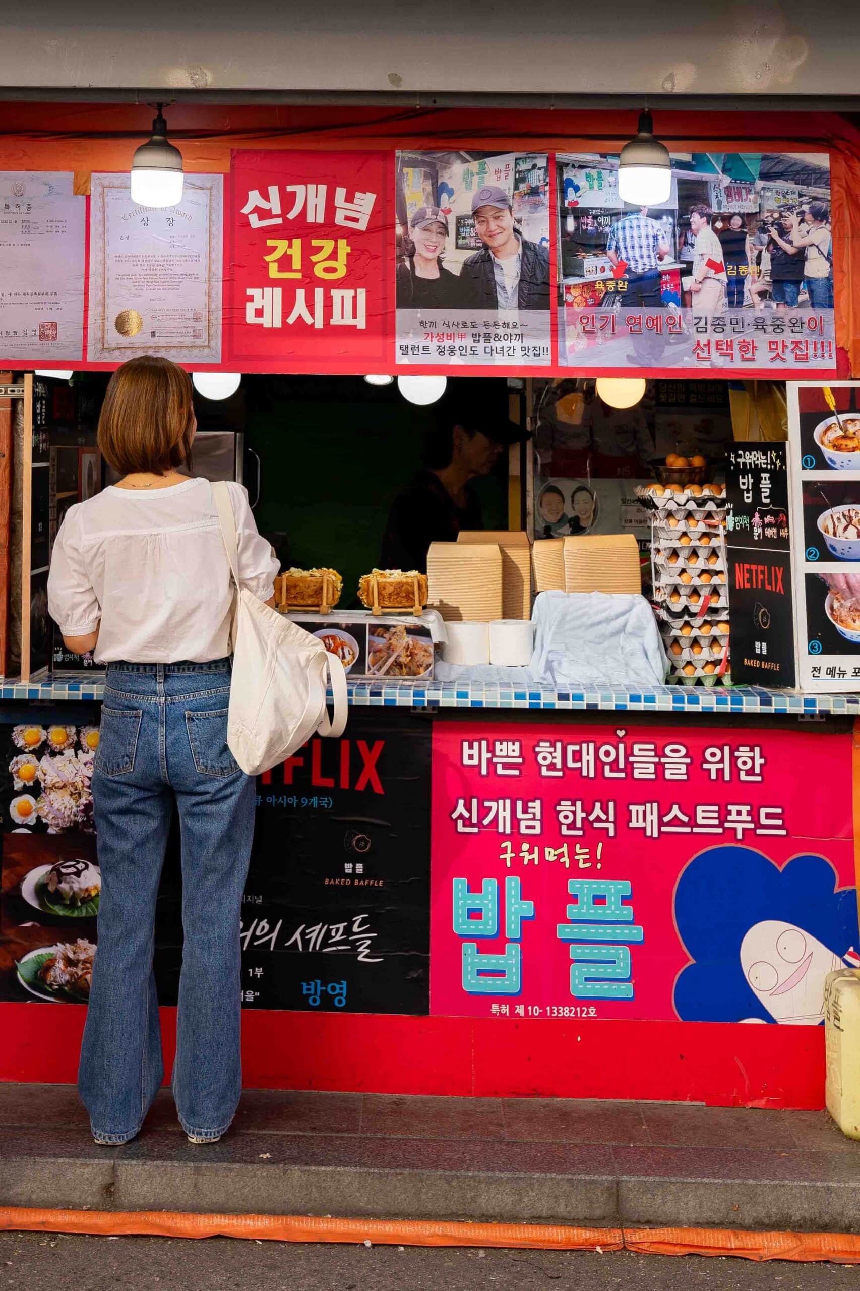 Jin is ordering a baked baffle from the Netflix food stand in Dongdaemun