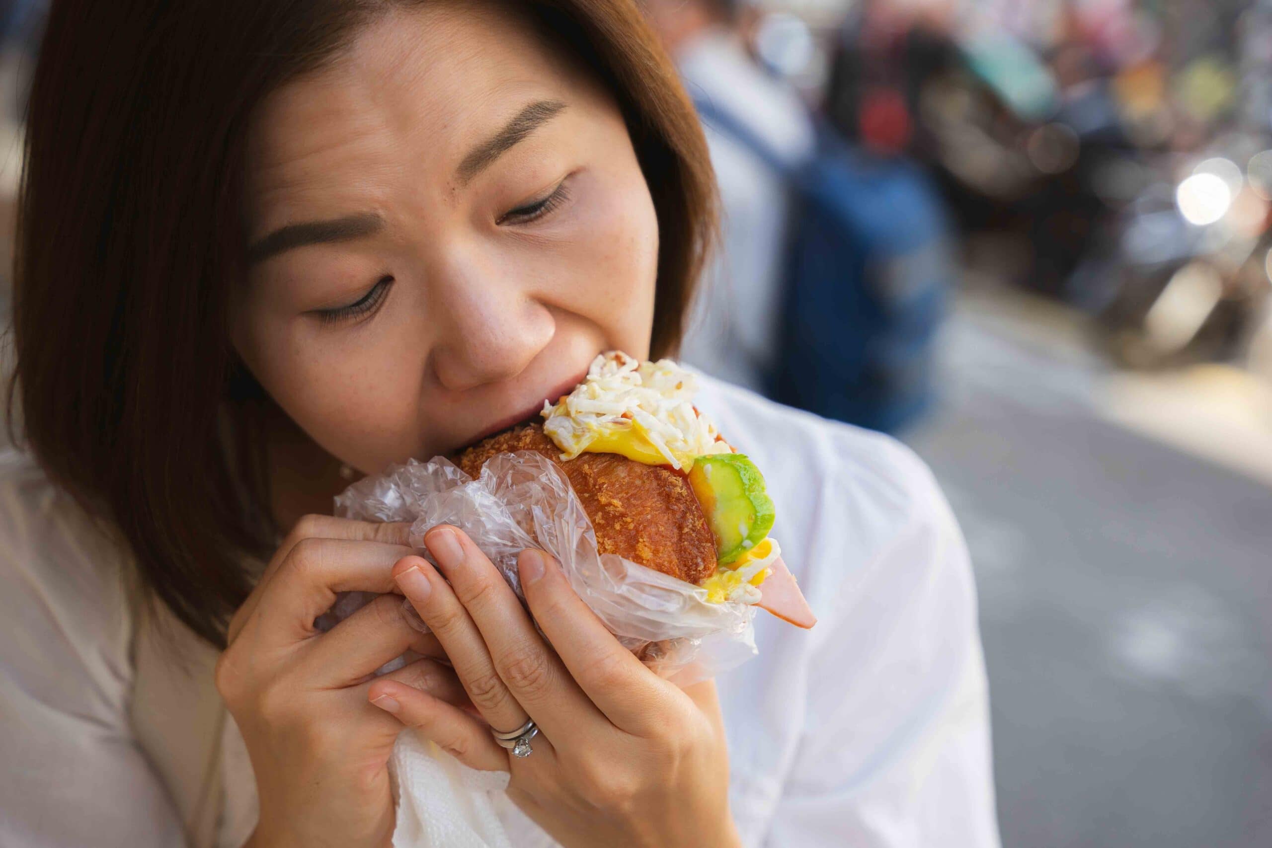 Jin taking a huge bite from the croquette we bought at the Vegetable Bread of Memory food stand in Dongdaemun Food Street