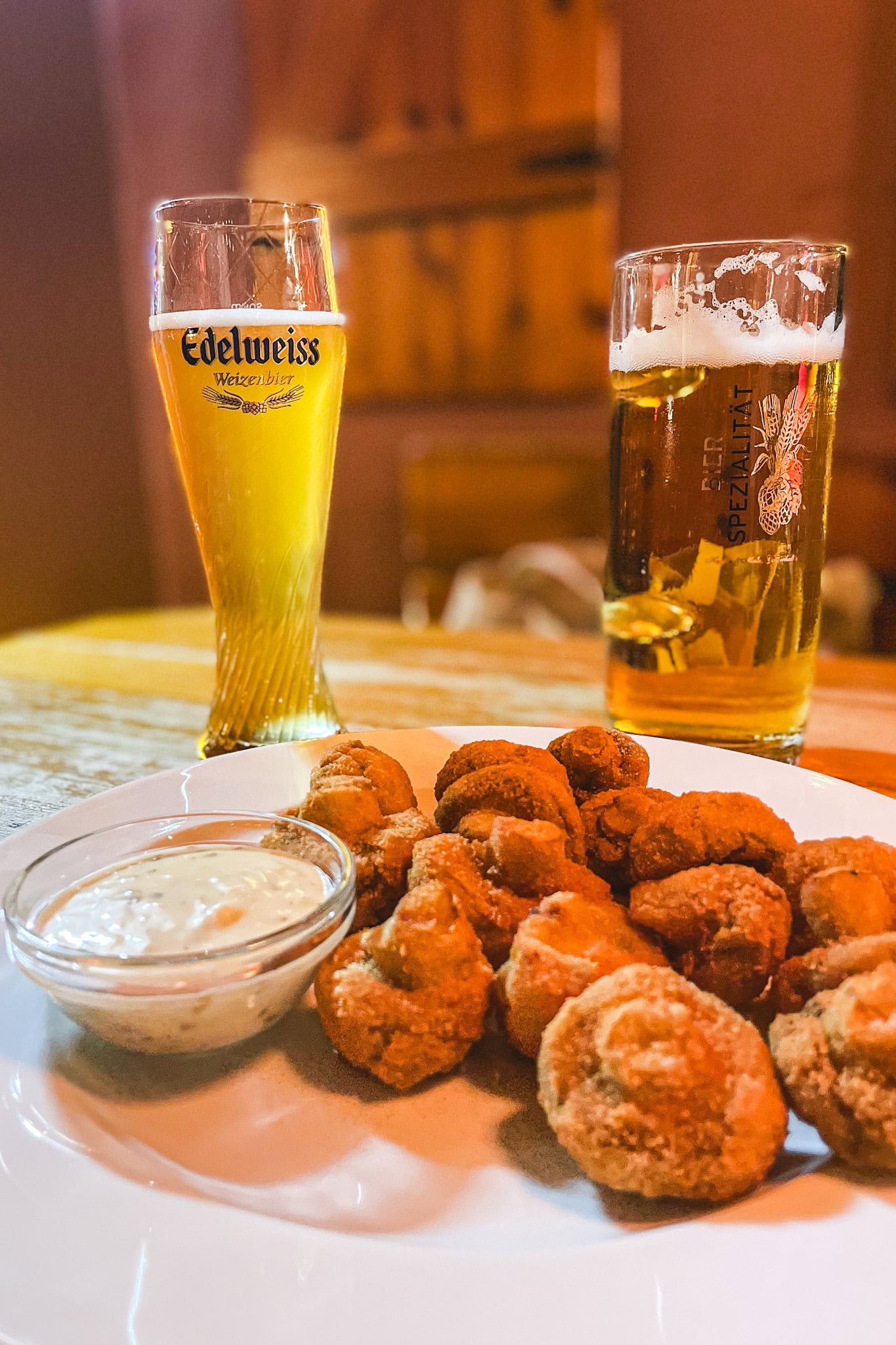 A plate of crumbed mushrooms with tartare sauce we had at Ribs of Vienna. There are also two draft beers on the table