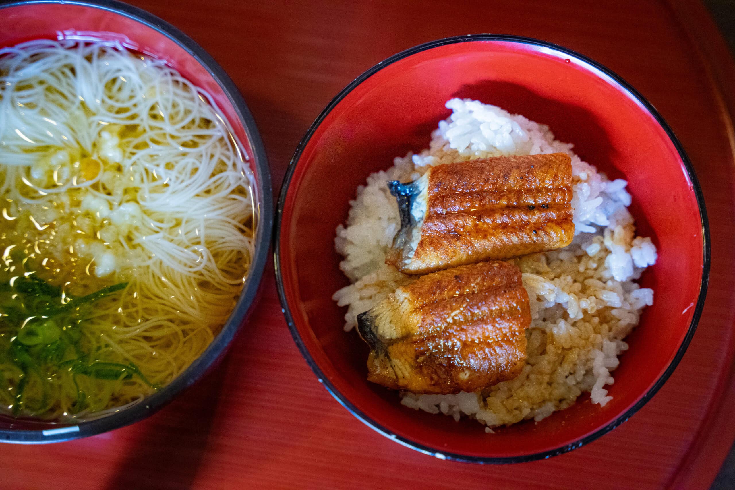 A bowl of somen noodles and a bowl of grilled eel and rice served in red lacquered bowls that we had at Kanoko restuarant in Nara