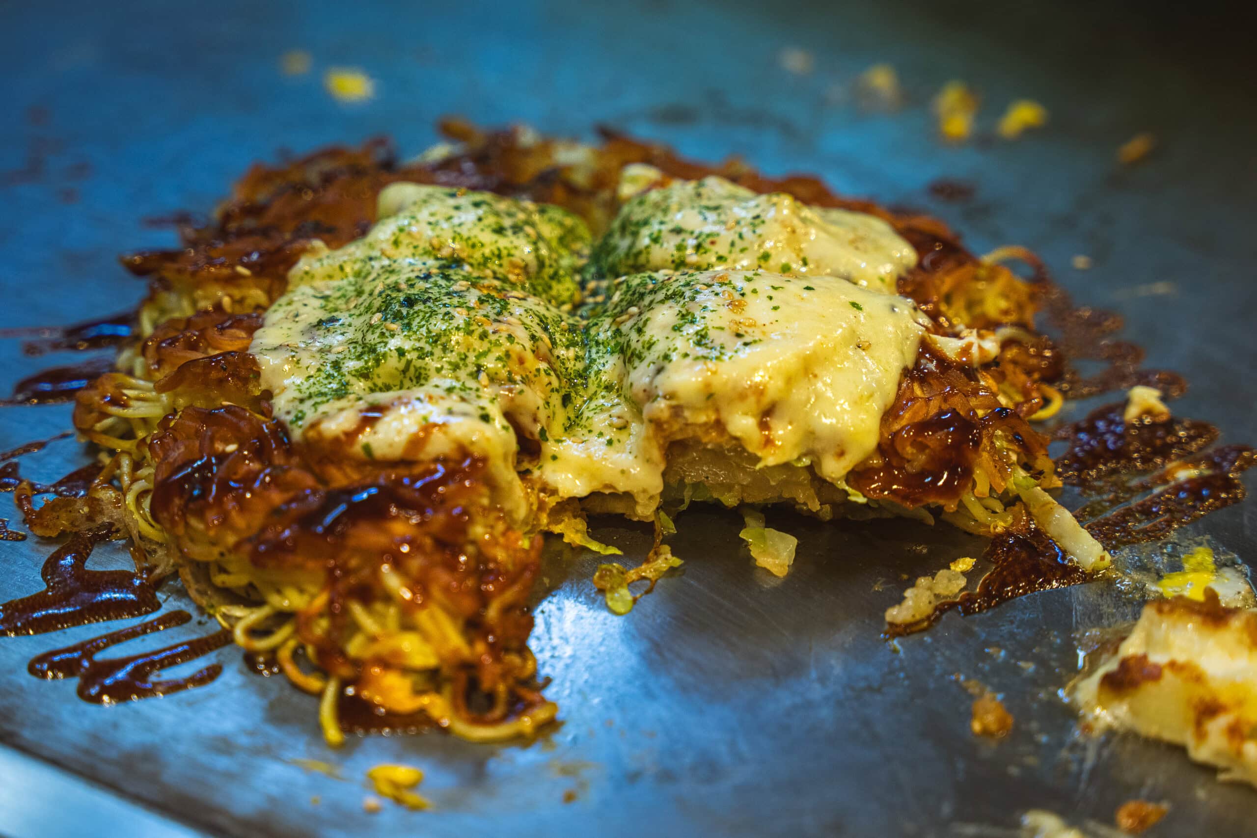 A Hiroshima-style okonomiyaki smothered in sauce and cheese that we had for lunch at Teppanyaki Acchan