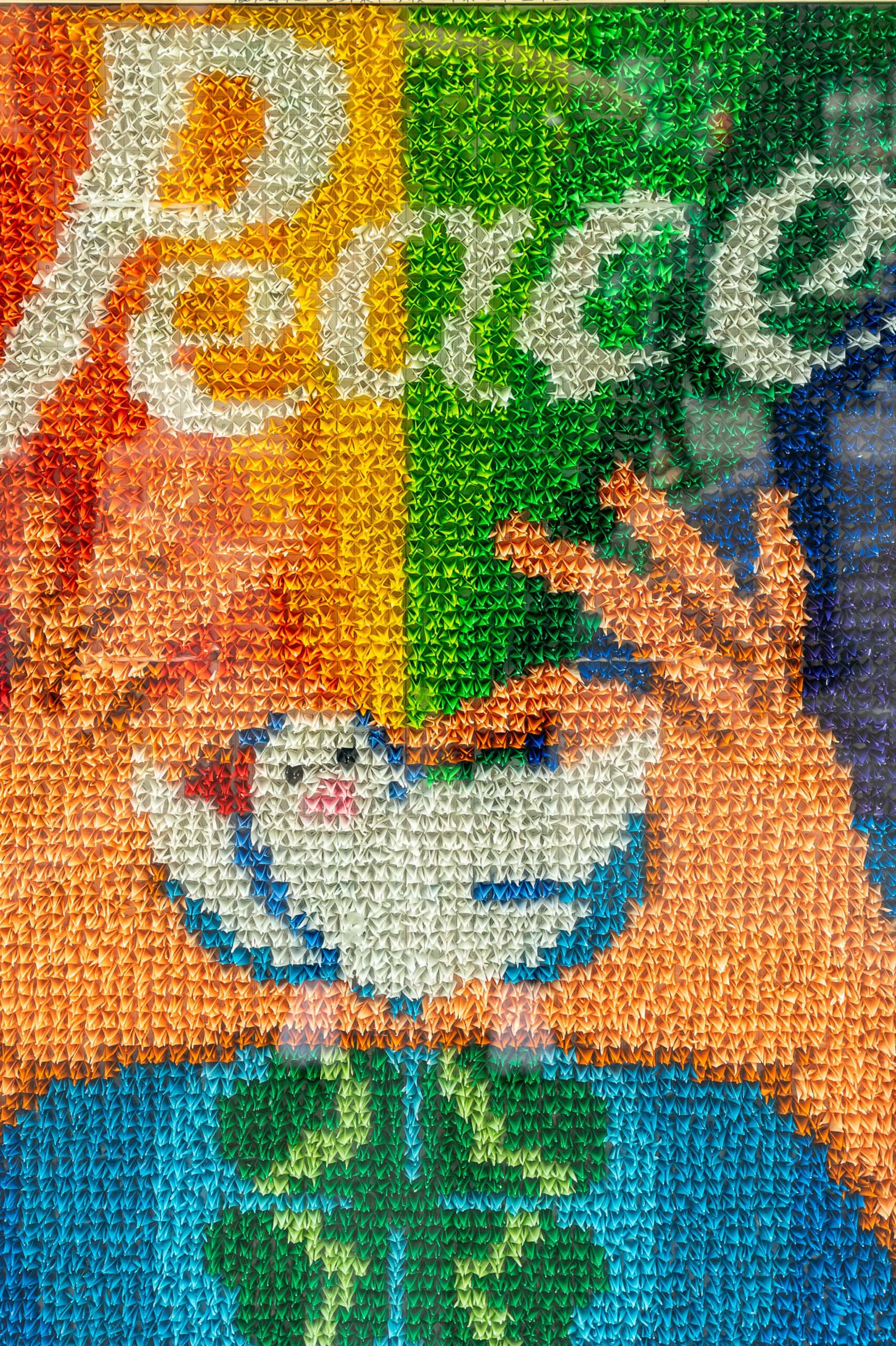 The word Peace and two hands holding a white dove made with origami cranes at the Children's Peace Memorial inside the Hiroshima Peace Memorial Park