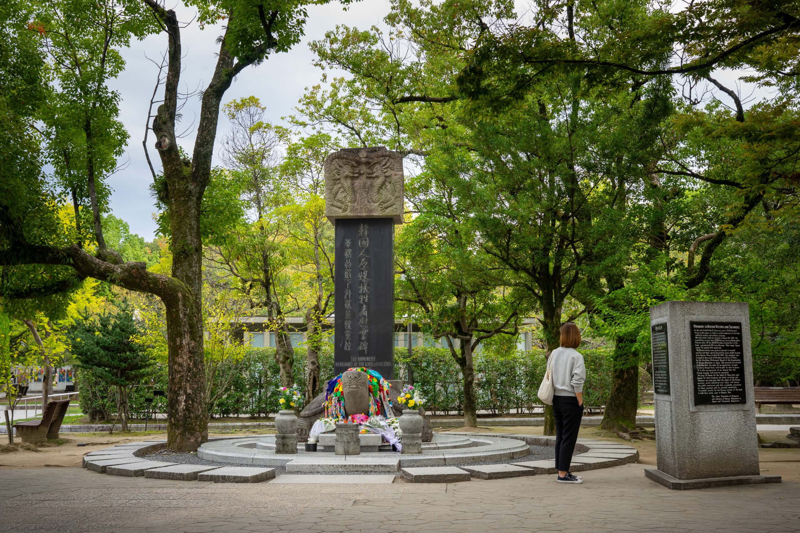 Jin standing at the Memorail for the Korean victims of the atomic bomb in Hiroshima Peace Memorial Park