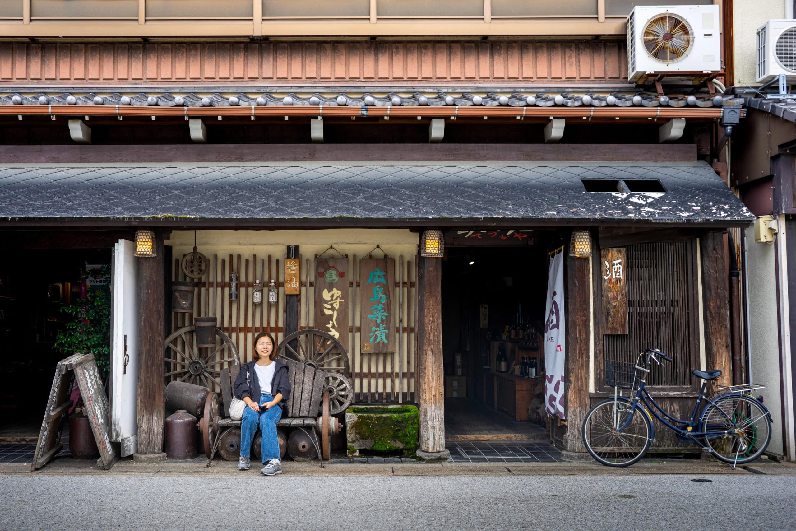 Jin sitting in front of a retro-looking restaurant on Omotesando Shotengai