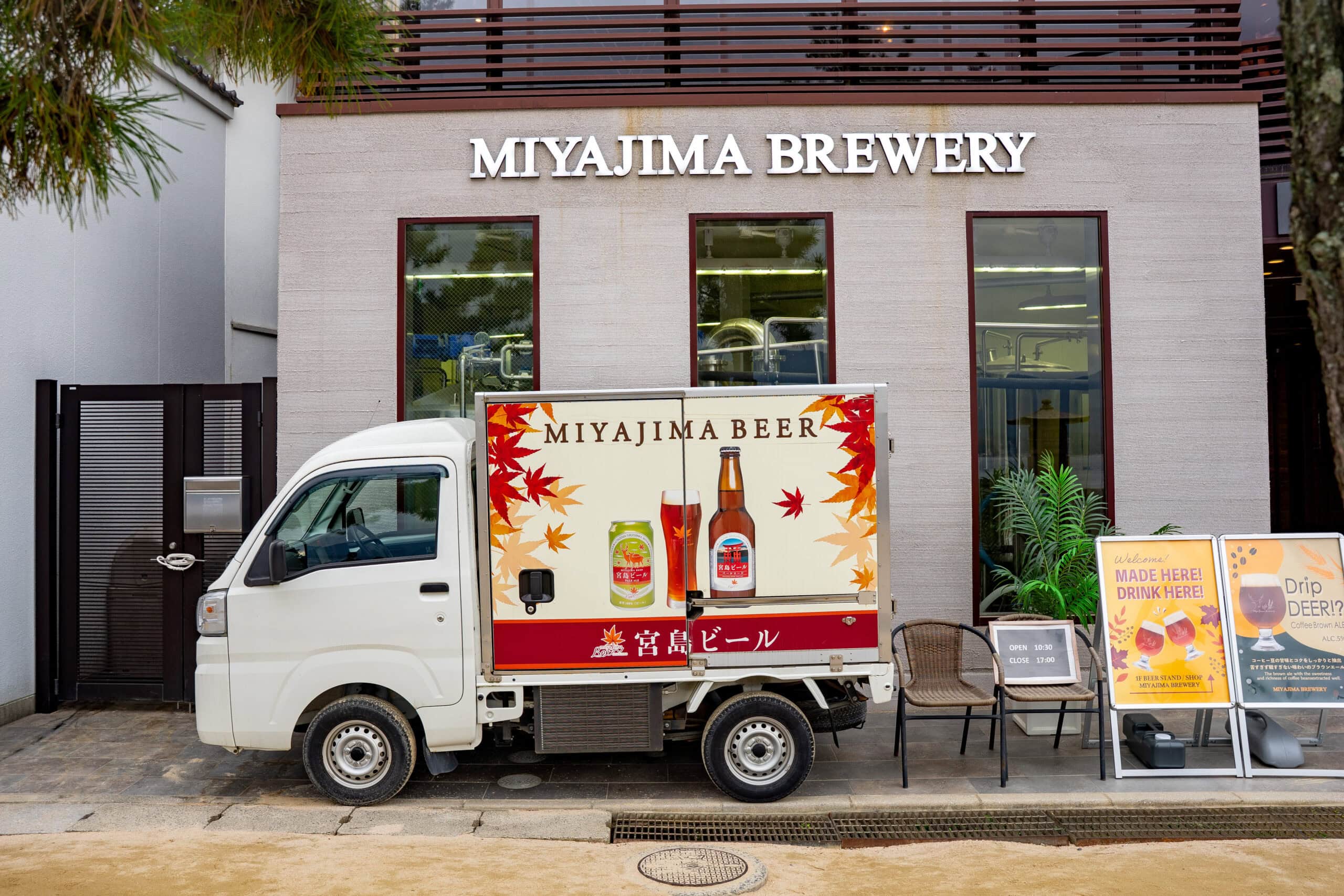 A tiny delivery truck stands in front of the Miyajima Brewery