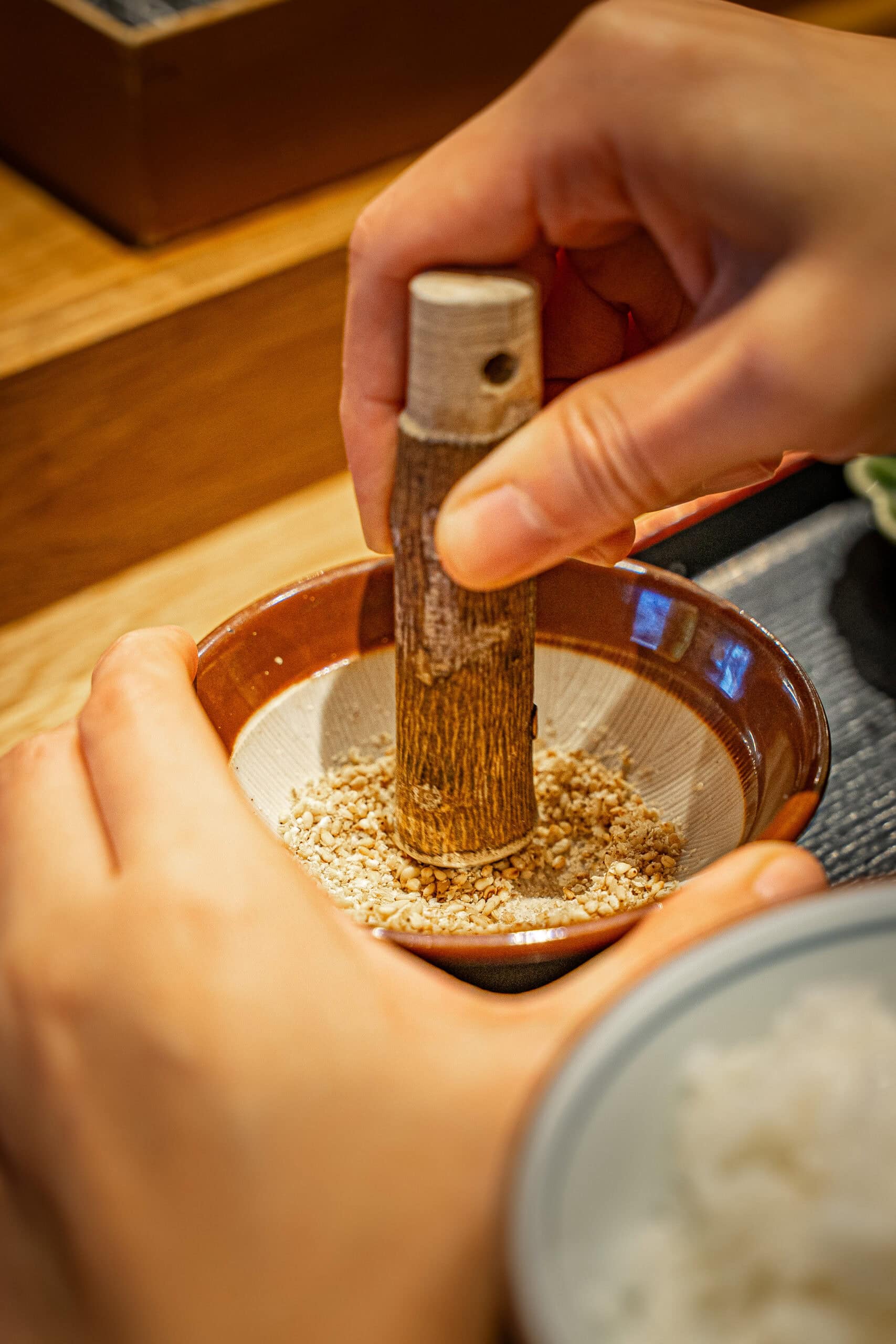 I am crushing sesame seeds in bowl that I will mix with katsu sauce