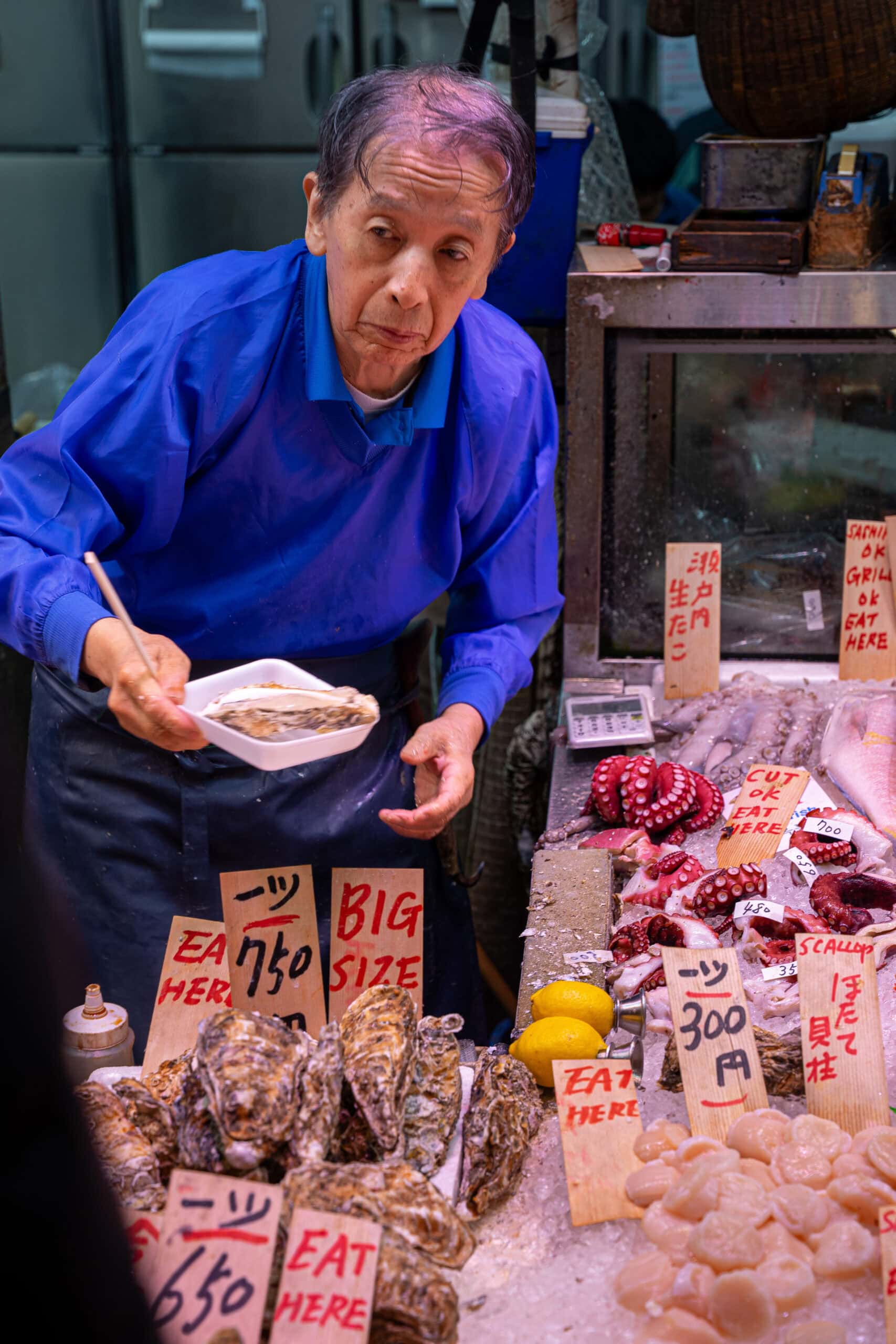 An elderly man sells oyesters in the Nishiki food market in Kyoto