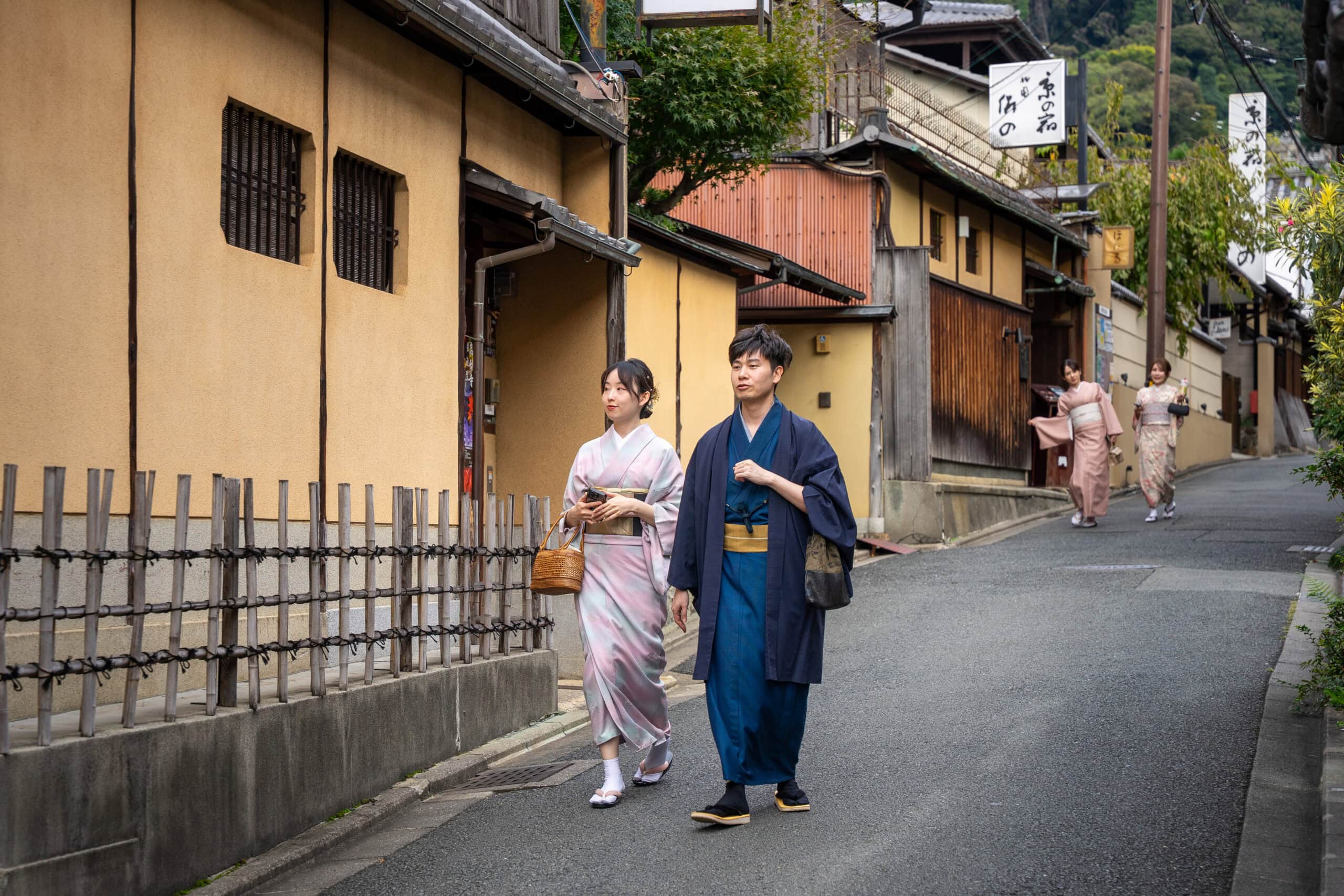 Asian tourists wearing traditional Japanese attire strolling in Kyoto