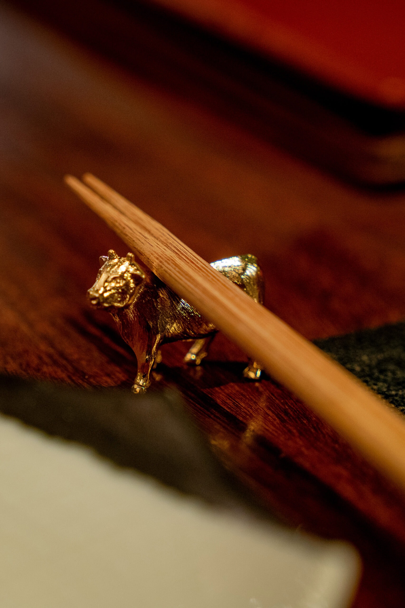 wooden chopsticks rest on a small golden cow at Yakiniku Asuka