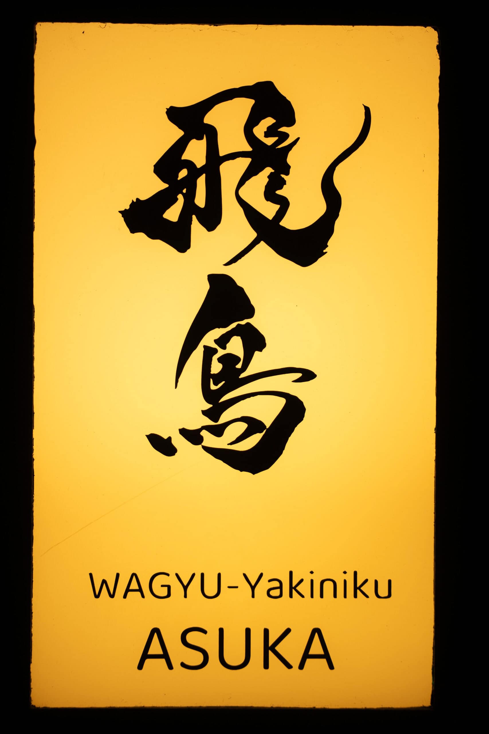 sing at the entrance to Yakiniku Asuka in Kyoto. The name is written in Japanese and English