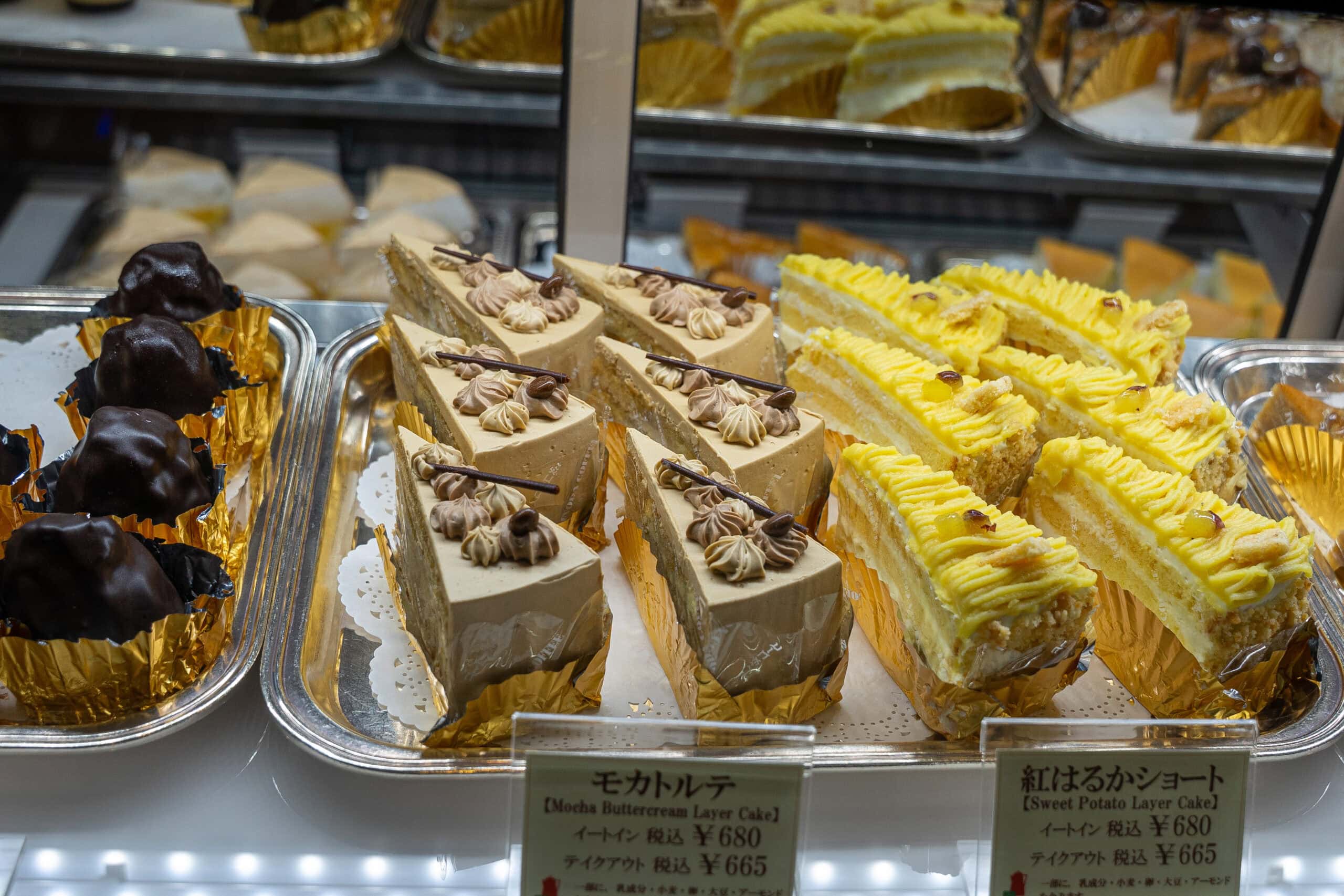 Slices of cake on display at Inoda Coffee, Sanjo Main branch. There are sweet potato layer cake and Mocha butter cream layer cake, selling for 680 yen per slice