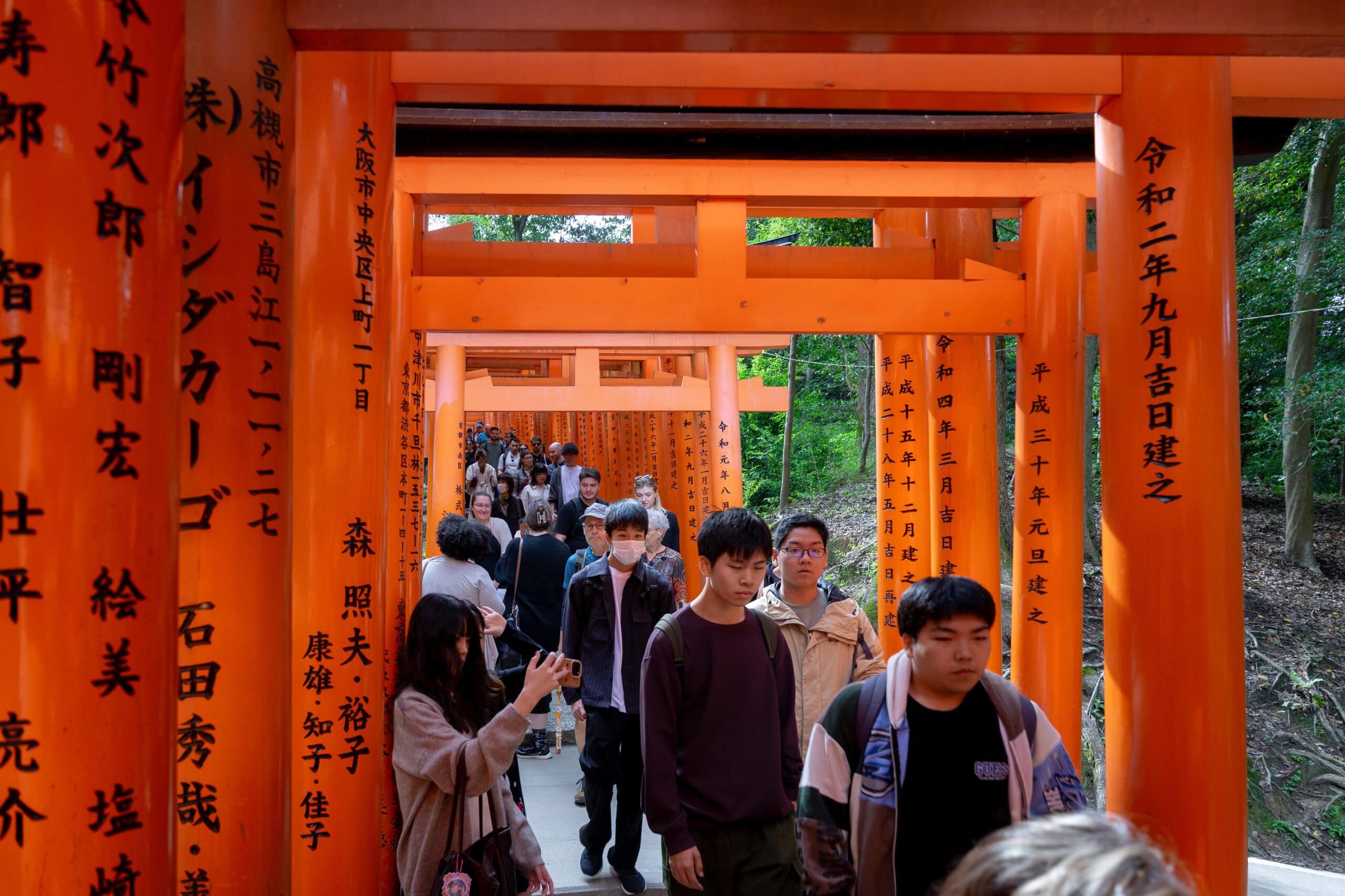 Hundreds of people seen walking under the torri gates of Fushimi Inari. It's seriously crowded