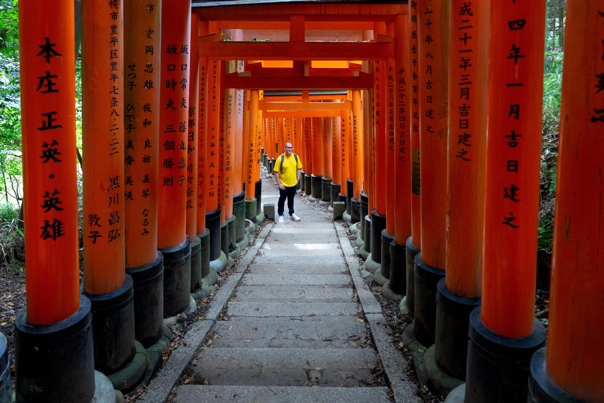 A photo of myself standing in the tunnel of red torii gates during our Fushimi Inari hike