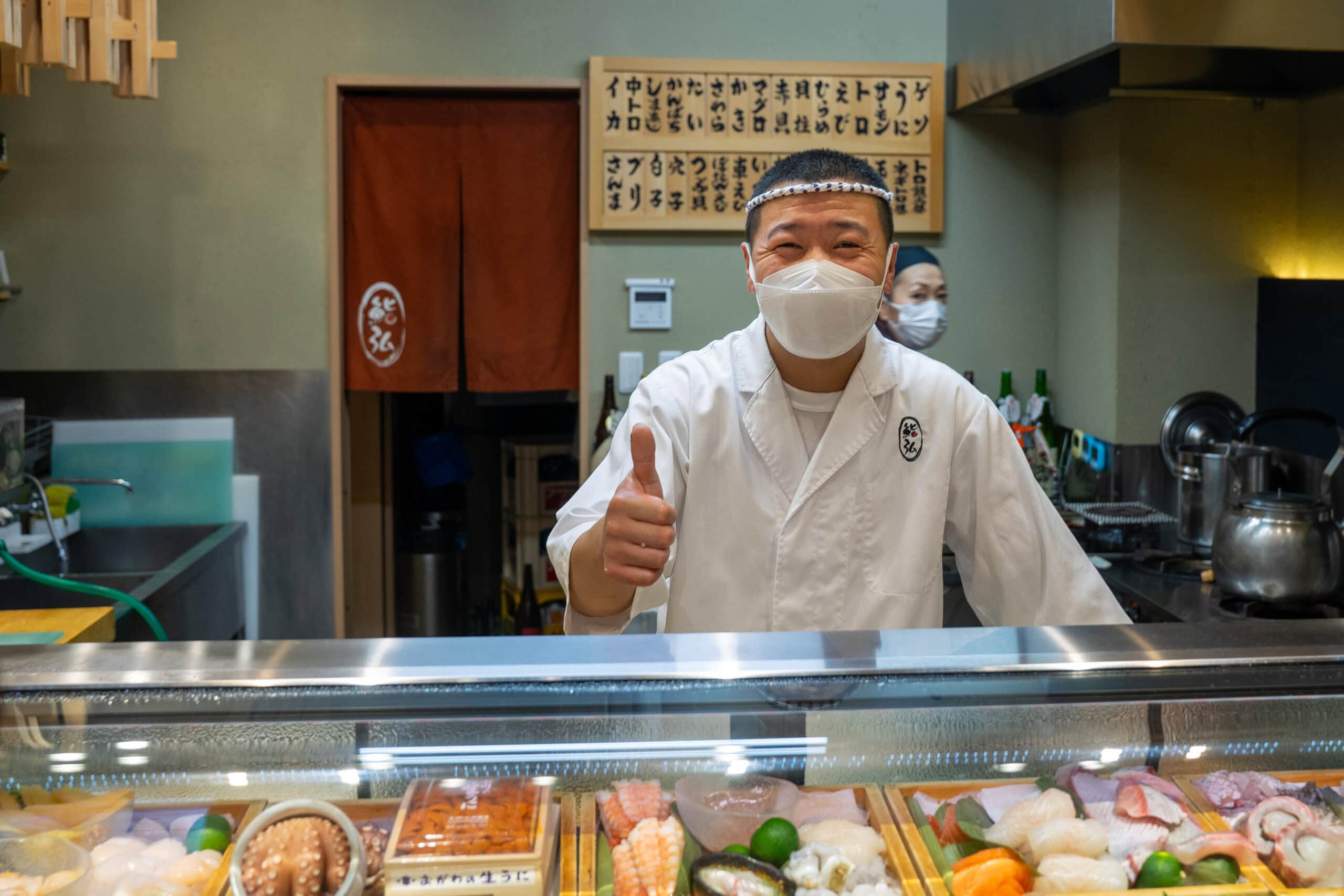 The sushi chef at Sushi Hiro gives us the thumbs up as we leave after our lunch
