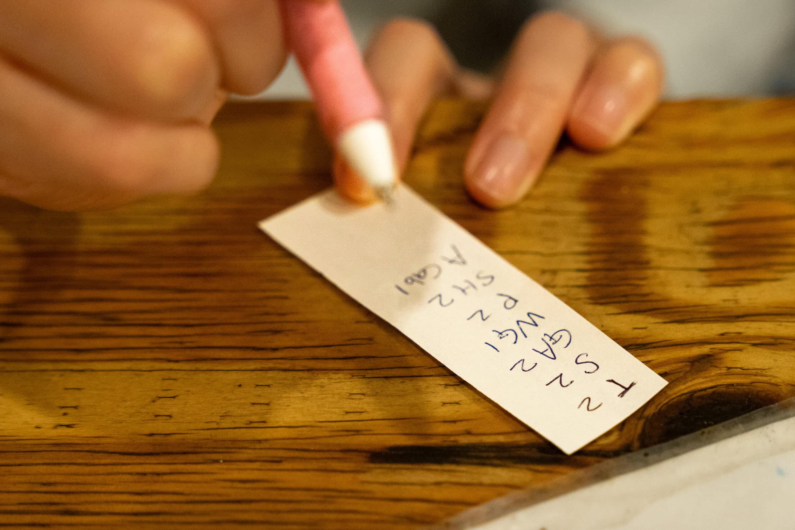 Jin writing down codes from the menu on a tiny piece of paper